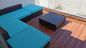 A balcony with wicker furniture and a view of the beach. - Apartment F3 1st line Carnon East, feet in the water (Mauguio)