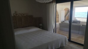 A bedroom with a large bed, a nightstand, and a sign that reads "dream". There is a sliding glass door leading to a balcony with a view of the sea. - T4 feet in water  (Ghisonaccia)