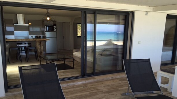 A modern interior with a kitchen, dining area, and a balcony with a view of the beach. - T4 feet in water  (Ghisonaccia)