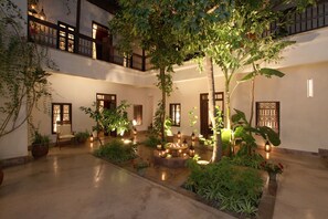 A courtyard with potted plants, a seating area, and traditional-style lanterns. - RIAD DAR AMAN, very peaceful 2 minutes from Jemaa el Fna Square (marrakech)