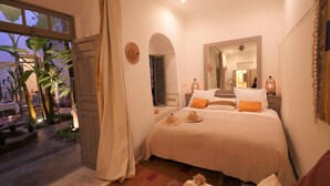 Een slaapkamer met een bed, een raam en een deur.