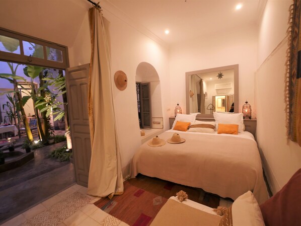 Een slaapkamer met een bed, een raam en een deur.