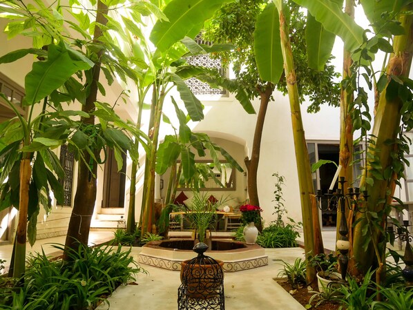A courtyard with a fountain, potted plants, and a seating area. - RIAD DAR AMAN, very peaceful 2 minutes from Jemaa el Fna Square (marrakech)