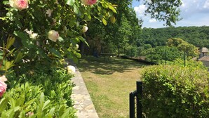 A garden pathway with blooming roses and a stone border. - Country house, quiet location, private pool. Country house. Magnificent view. (Montcuq en Quercy Blanc)