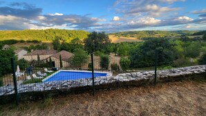 A pool area with a view of a rural landscape, including houses and trees. - Country house, quiet location, private pool. Country house. Magnificent view. (Montcuq en Quercy Blanc)
