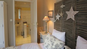 Une chambre à coucher comprenant un lit, une table de chevet, une lampe et une décoration murale en forme d’étoile.