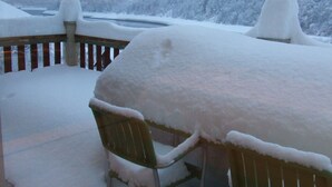 A snow-covered outdoor area with a table and chairs, a wooden fence, and a mountainous backdrop. - Vaujany, alpes d'huez, ski, bike, hike, trail chalet 40m2 2/5p, (Vaujany)