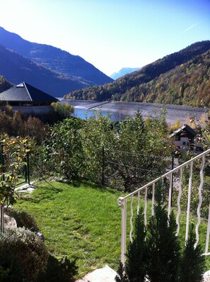 Paisatge de muntanya amb un riu, un edifici amb teulada fosca i una escala que baixa.