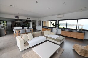 A modern living room with a sectional sofa, a dining area, and a kitchen. - CALVI, SEA VIEW, MODERN VILLA, HEATED POOL, JACUZZI,  (Calvi)