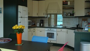 A kitchen with white cabinets, a built-in oven, and a coffee maker.
