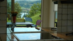 A kitchen with a view of a river and mountains.