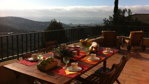 Mesa de comedor al aire libre con vistas a la ciudad y las colinas.
