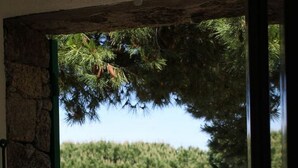 Un mur de pedra amb una finestra oberta.