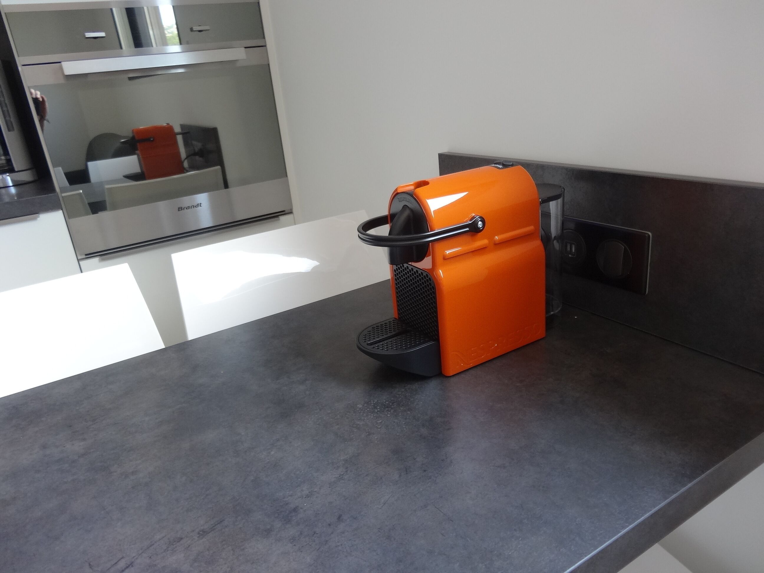 A kitchen with a modern espresso machine on a countertop.