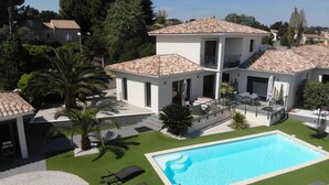 A modern villa with a swimming pool, a covered patio, and a well-maintained garden. - NEAR PEZENAS, lovely villa, private heated pool, quiet location, shops. (Tourbes)