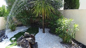 A garden with a water feature, rocks, and various plants. - NEAR PEZENAS, lovely villa, private heated pool, quiet location, shops. (Tourbes)