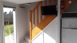 Una escalera con barandilla de madera y un televisor de pantalla plana en la pared.