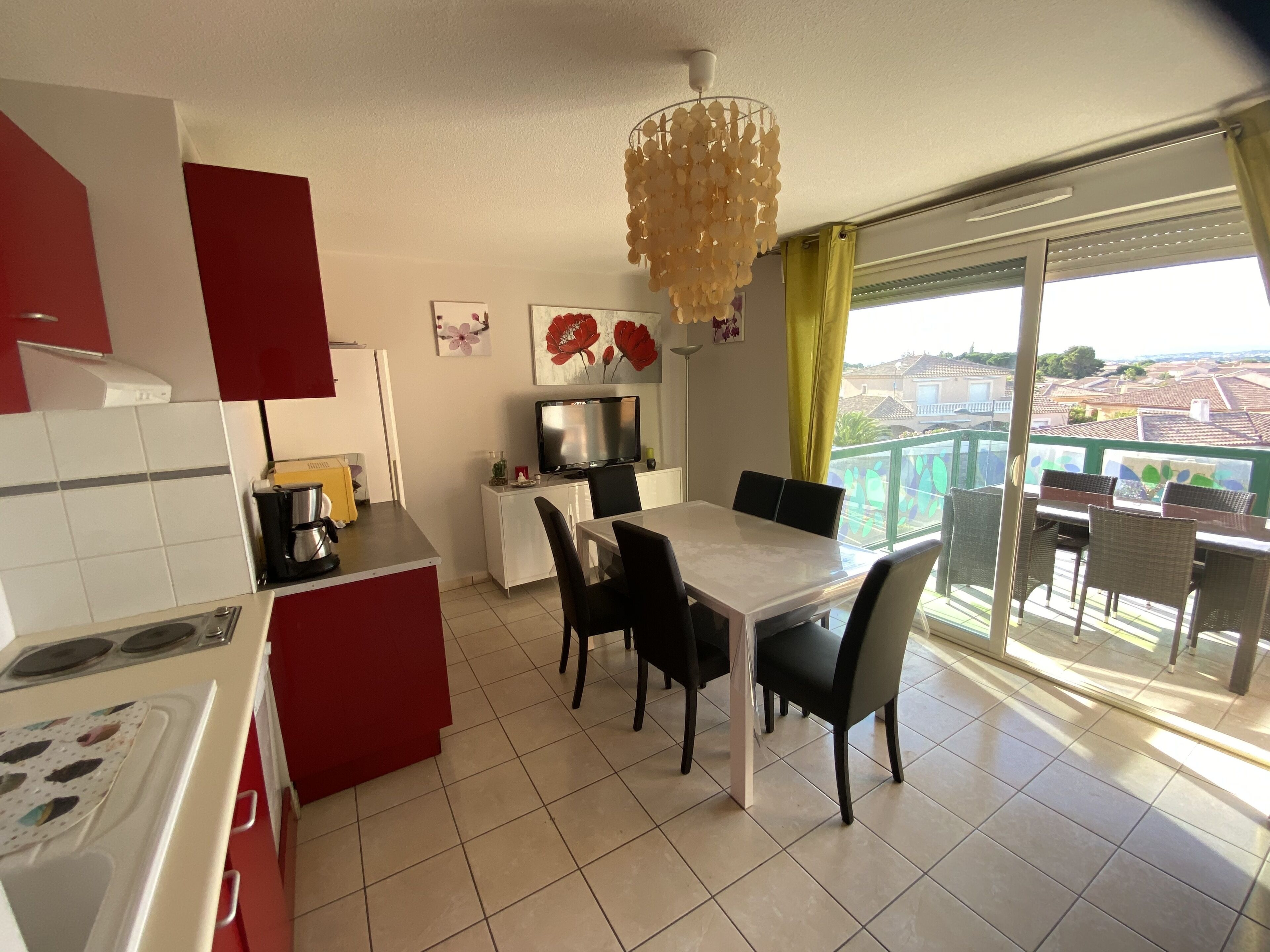Une cuisine moderne avec un coin repas et un balcon offrant une vue agréable.