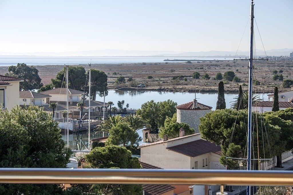 A coastal residential area with houses, a marina, and a body of water.