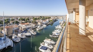 Un port de plaisance où des bateaux sont amarrés le long d’un canal, entouré de bâtiments et de verdure.