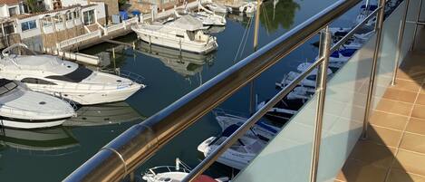 A marina with boats docked, a clear view of the surrounding town, and a balcony with a railing.