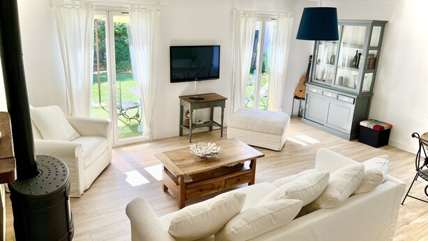 Una sala de estar con un sofá, una mesa de centro, un televisor y un mueble.