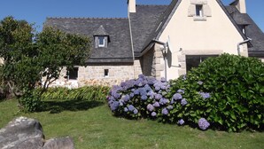 A stone house with a gabled roof and a small window.