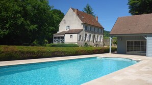 A swimming pool with a house in the background.