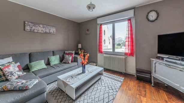 Un soggiorno moderno con un divano grigio, un tavolino e una TV.