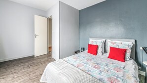 Una camera da letto con un letto, un comodino e una porta che dà su un'altra stanza.