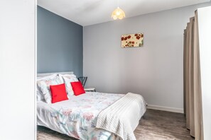 A bedroom with a bed, pillows, a wall art piece, and a window with curtains. - Homerez - House in Bourbon-Lancy (Bourbon-Lancy)
