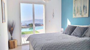 Une chambre avec un lit, une vue sur une piscine et des montagnes, et un tableau accroché au mur.