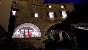 Een gebouw van steen met boogvensters en een verlicht middengedeelte.
