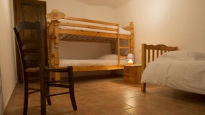A dormitory room with bunk beds, a wooden chair, a small bedside table with a lamp, and a door. - In a mansion of the nineteenth century, cottage for 5 people (forcalquier)
