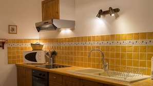 A kitchen with wooden cabinets, a built-in microwave, a sink with a dish rack, and a dishwasher. - In a mansion of the nineteenth century, cottage for 5 people (forcalquier)