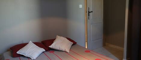 Un dormitorio con cama, almohadas y una puerta.