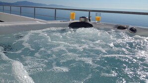 A hot tub with water jets, two glasses of orange juice, and a view of the sea and mountains. - Villa by the sea - Breathtaking sea view & infinity pool - Costa del Sol (manilva)