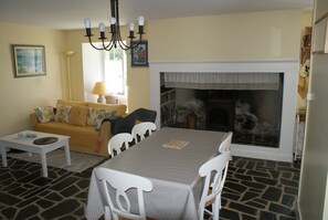 A living room with a fireplace, a dining table, and a sofa. - 18th Century mill, nice furnishing and decoration by the river (Dampniat)
