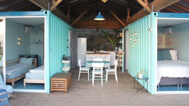 Un logement compact, avec un espace de vie ouvert comprenant deux chambres, un coin cuisine et un coin repas.
