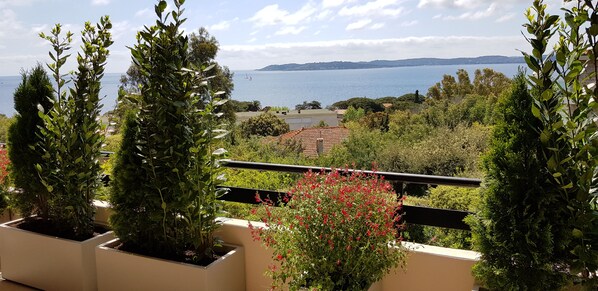 En balkon med plantekasser og havudsigt.