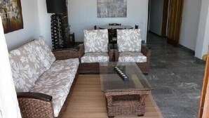 A living room with a sofa, two armchairs, a glass coffee table, and a lamp. - ROSES: Super Apartment on the FIRST LINE OF THE SEA for 6–8 PEOPLE in the CITY CENTER (ROSAS)