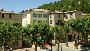 Une vue de rue avec des bâtiments, des arbres et une colline.