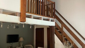 A spacious living area with a high ceiling and exposed wooden beams, a comfortable sofa set, a flat-screen TV, and a dining table with a vase. - Villa with all comforts, PRIVATE SWIMMING POOL - NO INCOMES - Ideal for families (Fontarèches)