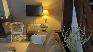 A cozy living room with a sofa, a TV mounted on the wall, a lamp, and a wooden staircase. - Villa with all comforts, PRIVATE SWIMMING POOL - NO INCOMES - Ideal for families (Fontarèches)