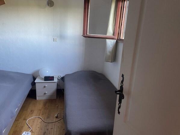 A small, tidy room with two single beds, a bedside table with a lamp, and a power outlet on the wall. - Villa with all comforts, PRIVATE SWIMMING POOL - NO INCOMES - Ideal for families (Fontarèches)