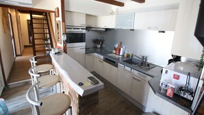 A kitchen with a central island, bar stools, a dishwasher, and a stove. - Great Pyrenees typical barn furnished with all modern comforts (Cadeilhan-Trachère)