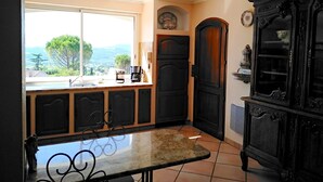 A kitchen with a view of the countryside, a coffee machine, and a dark wooden cabinet. - Beautiful villa with SWIMMING POOL and PANORAMIC VIEW - Residential setting (Vinsobres)