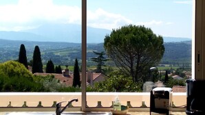 A kitchen with a sink, a coffee maker, and a view of a green landscape with trees and mountains. - Beautiful villa with SWIMMING POOL and PANORAMIC VIEW - Residential setting (Vinsobres)