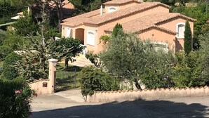 A Mediterranean-style villa with a tiled roof, surrounded by lush greenery and tall cypress trees. - Beautiful villa with SWIMMING POOL and PANORAMIC VIEW - Residential setting (Vinsobres)