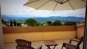 A balcony with a table and chairs, overlooking a scenic landscape with mountains and trees. - Beautiful villa with SWIMMING POOL and PANORAMIC VIEW - Residential setting (Vinsobres)